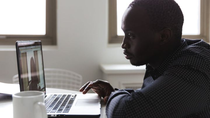 Someone taking a video call at a desk with a laptop