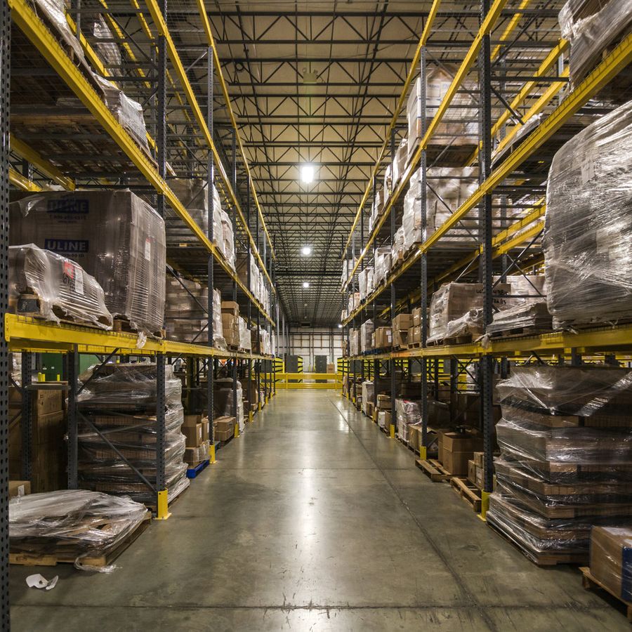 A warehouse aisle lined with racking and palletised stock